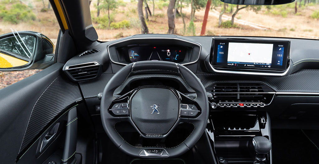 Vue conducteur du tableau de bord i-Cockpit 3D Peugeot 208 GT avec écran numérique 10 pouces et écran tactile central allumés, petit volant au premier plan